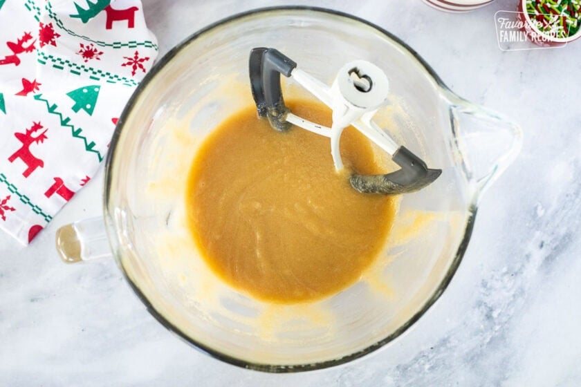 Glass stand mixing bowl with mixed butter and sugar with paddle attachment.