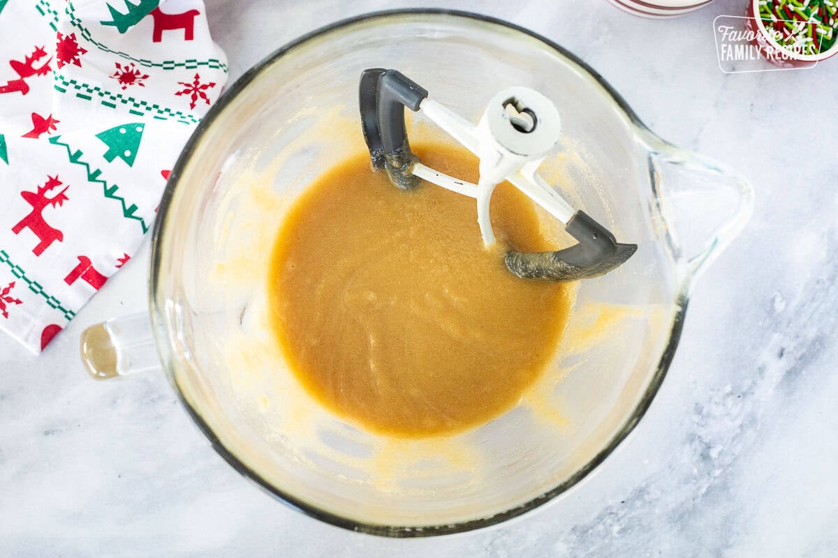 Glass stand mixing bowl with mixed butter and sugar with paddle attachment.