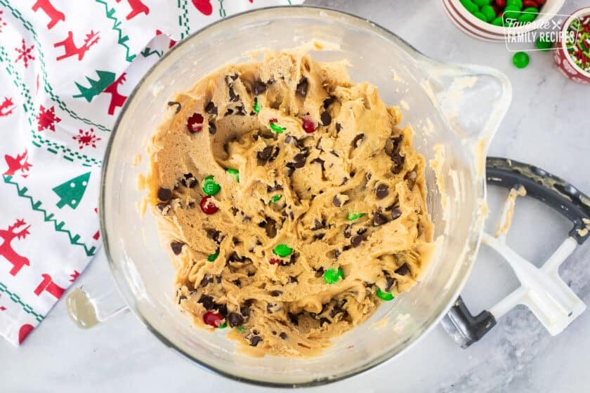 Glass mixing bowl with Christmas cookie bar dough and paddle attachment on the side.