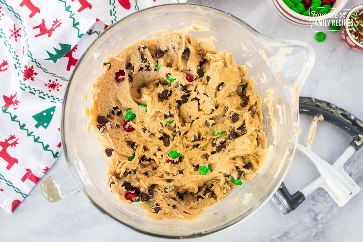 Glass mixing bowl with Christmas cookie bar dough and paddle attachment on the side.