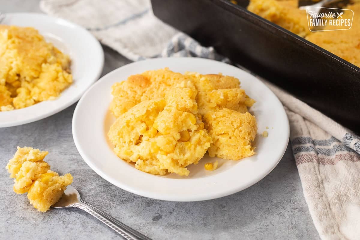 Two plates with cornbread pudding and fork.