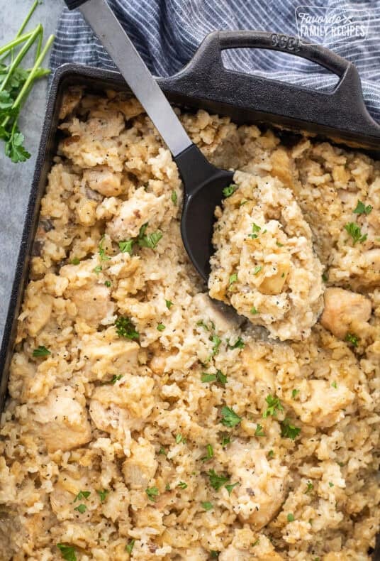 Spoon resting in baking dish of easy chicken casserole.