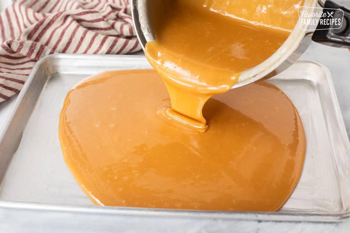 Pouring hot caramel onto a greased sheet pan.