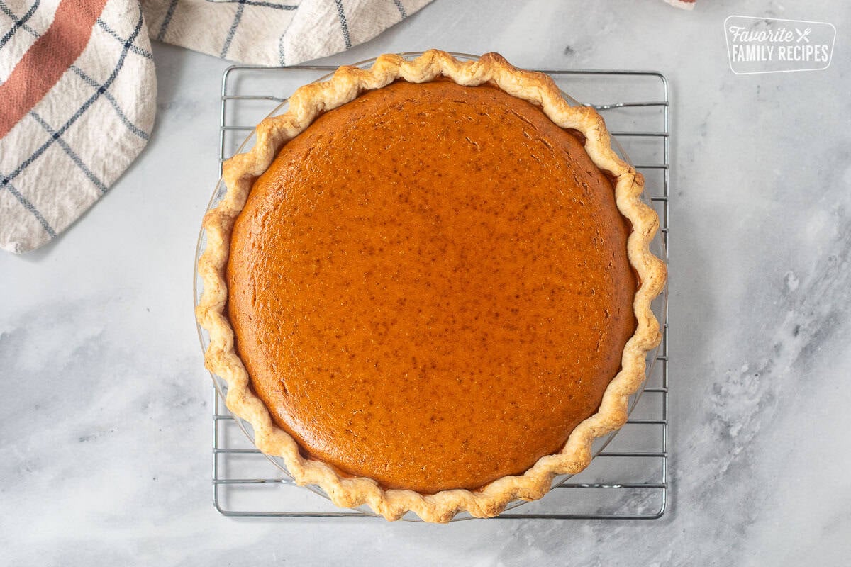 Baked pumpkin pie on a cooling rack.