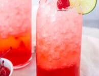 Glasses of Shirley Temple Drinks garnished with lime slices and cherries.