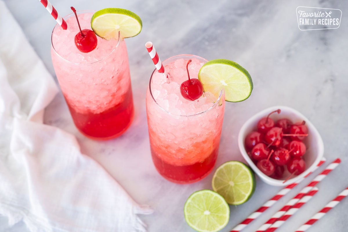 Shirley Temple Drinks garnished with lime slices and cherries.