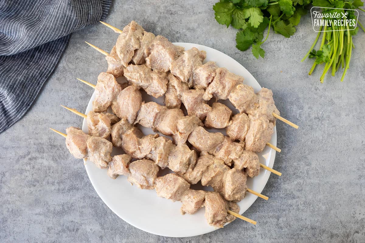 Plate with skewered pieces of marinated chicken.