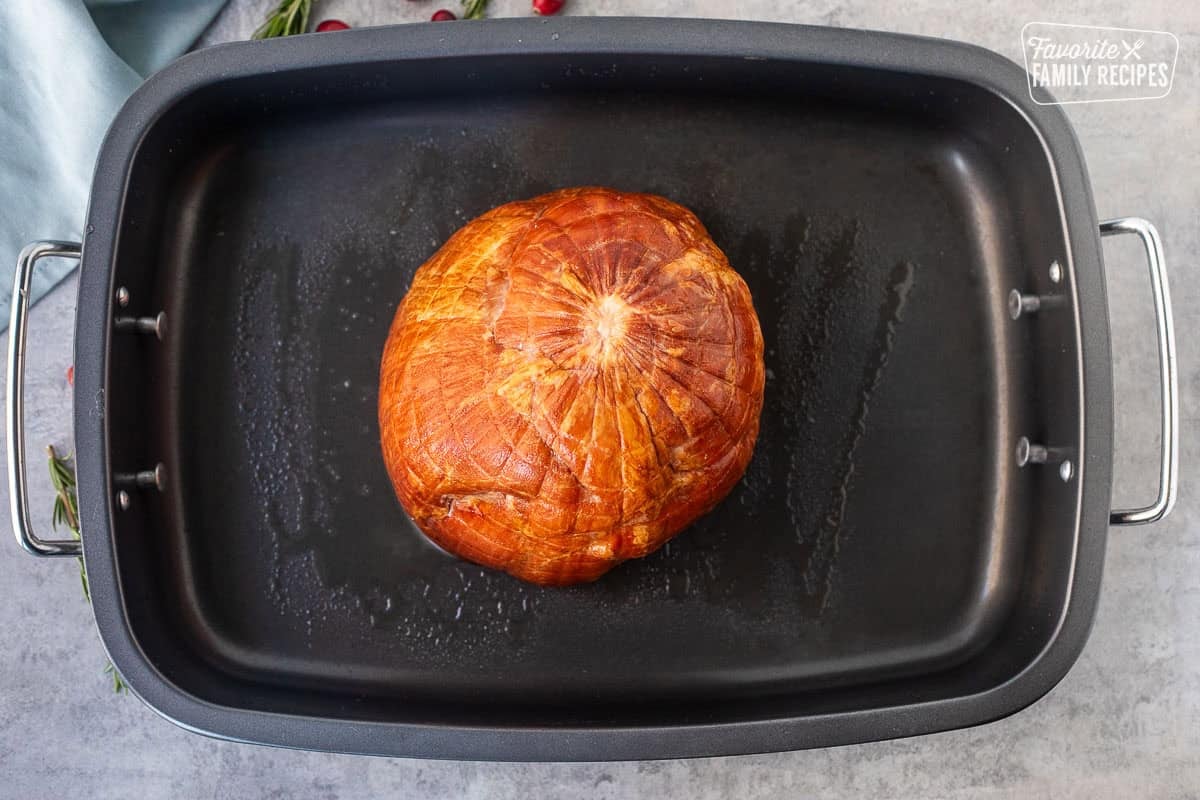 Roasting pan with non stick spray and ham face side down.