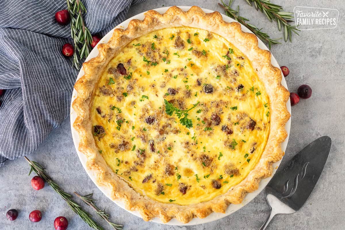 Baked Christmas Quiche garnished with parsley. Spatula on the side.