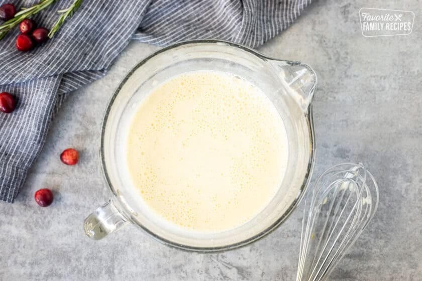 Mixing bowl with egg mixture and whisk on the side.