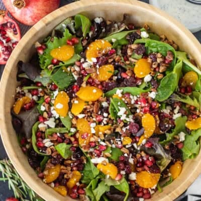 Large wooden bowl with Christmas salad and poppyseed dressing.