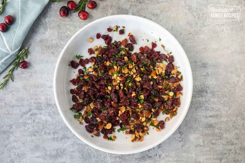 Glass dish with combined raisins, parsley and chopped almonds.
