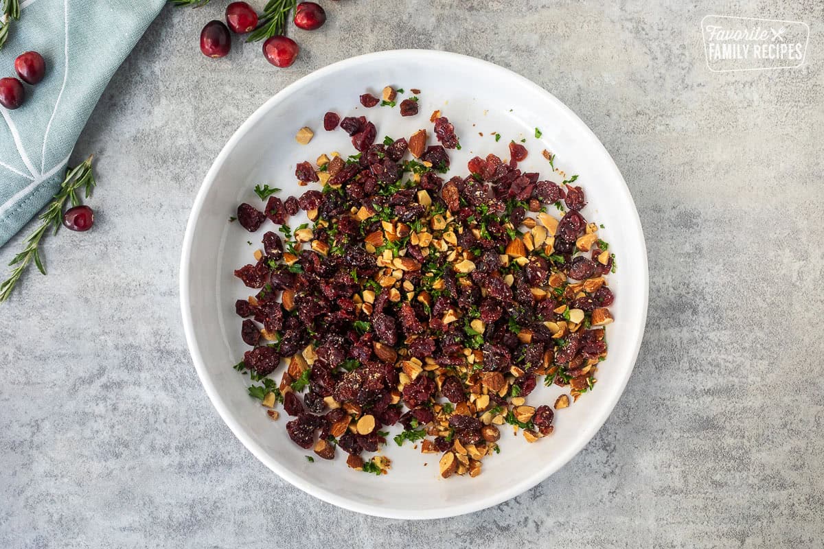 Glass dish with combined raisins, parsley and chopped almonds.
