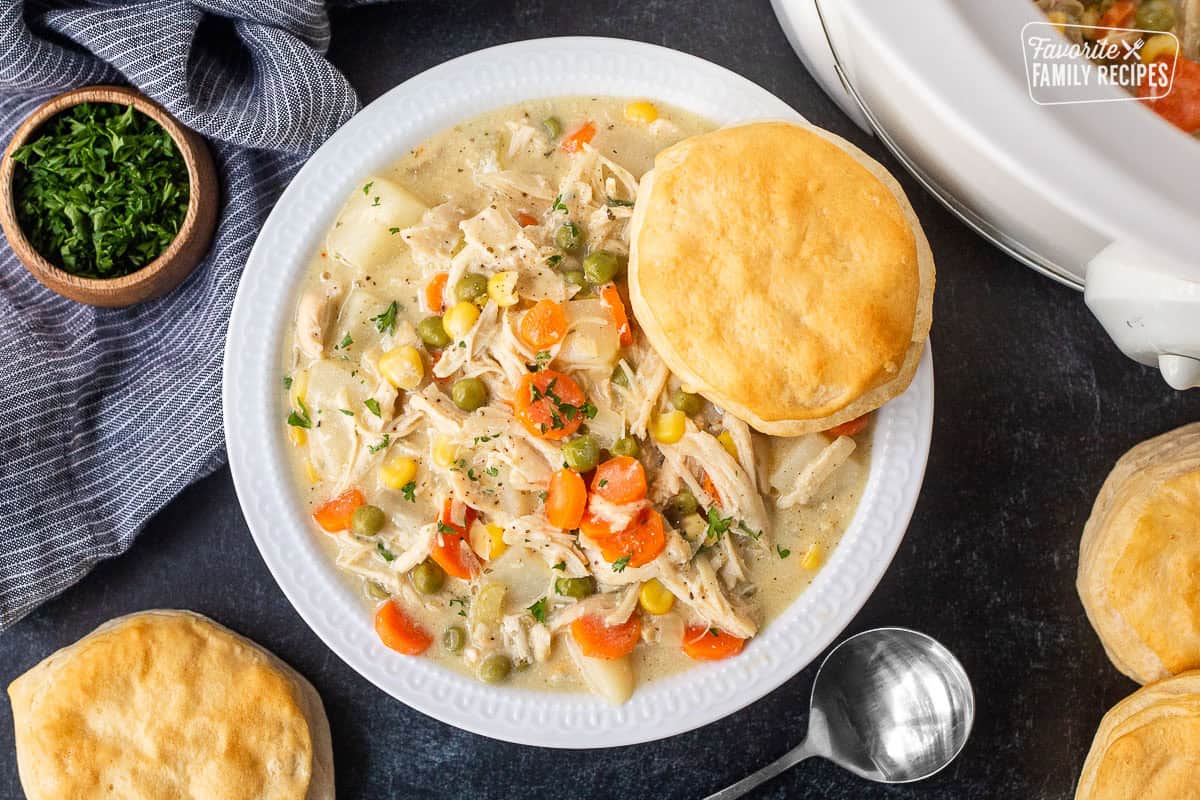Bowl of crock pot chicken pot pie with a biscuit resting on top.