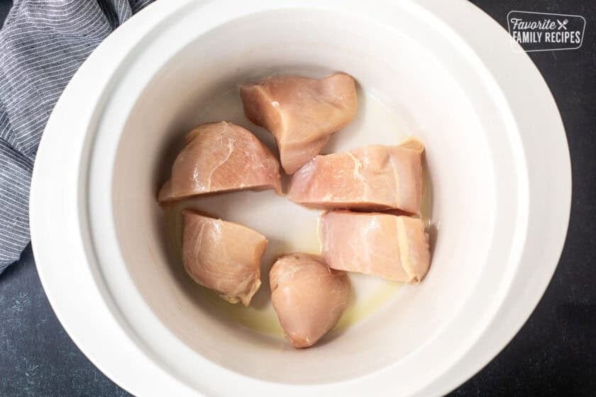 Sliced chicken breast in a crock pot.