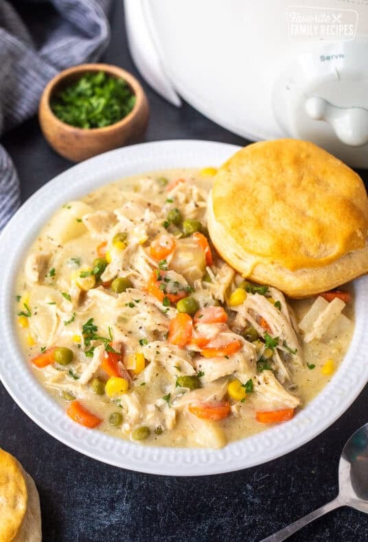 Bowl of crock pot chicken pot pie with a biscuit resting on top.
