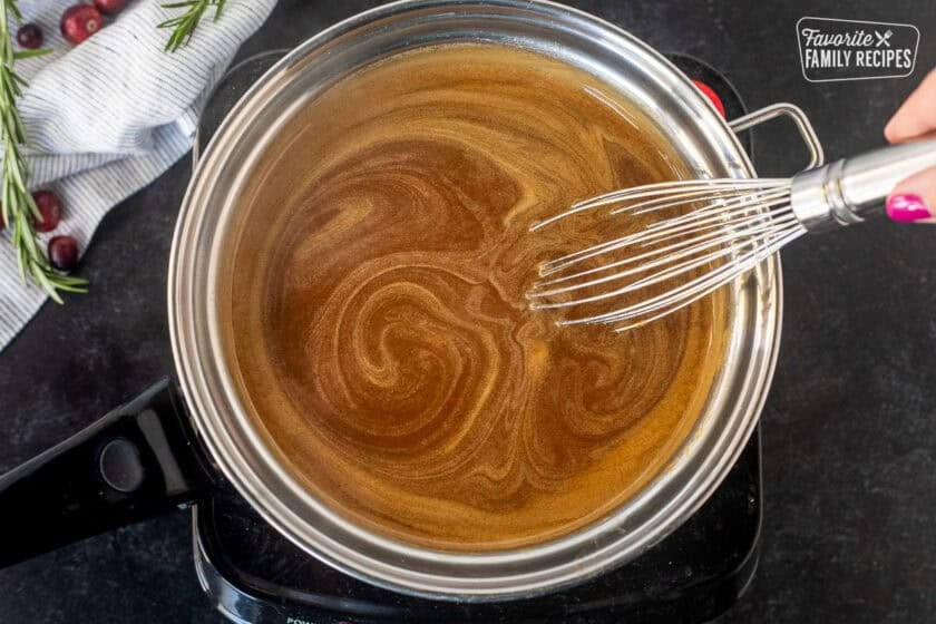 Sauce pan of hot gingerbread syrup and a whisk.