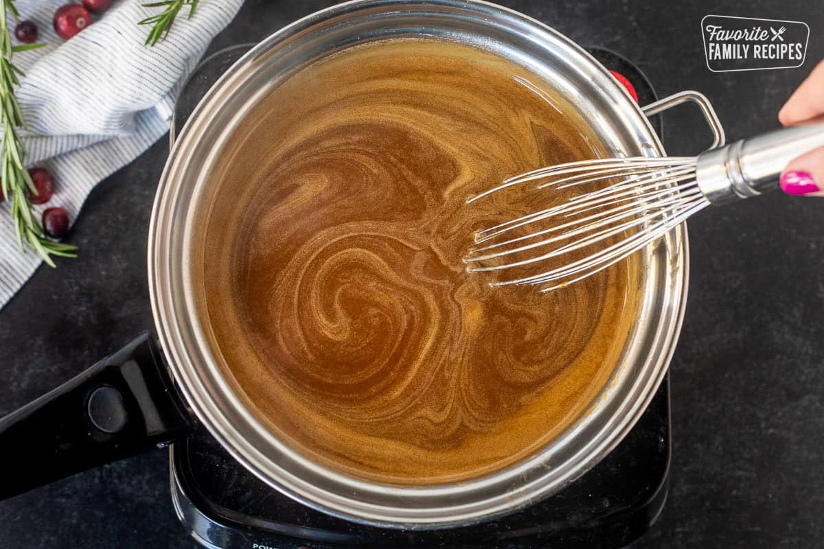 Sauce pan of hot gingerbread syrup and a whisk.