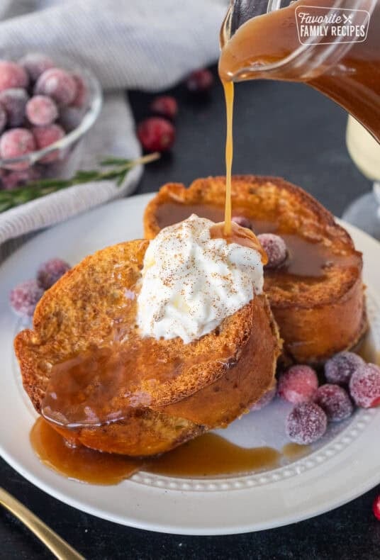Pouring gingerbread syrup on top of eggnog French toast.