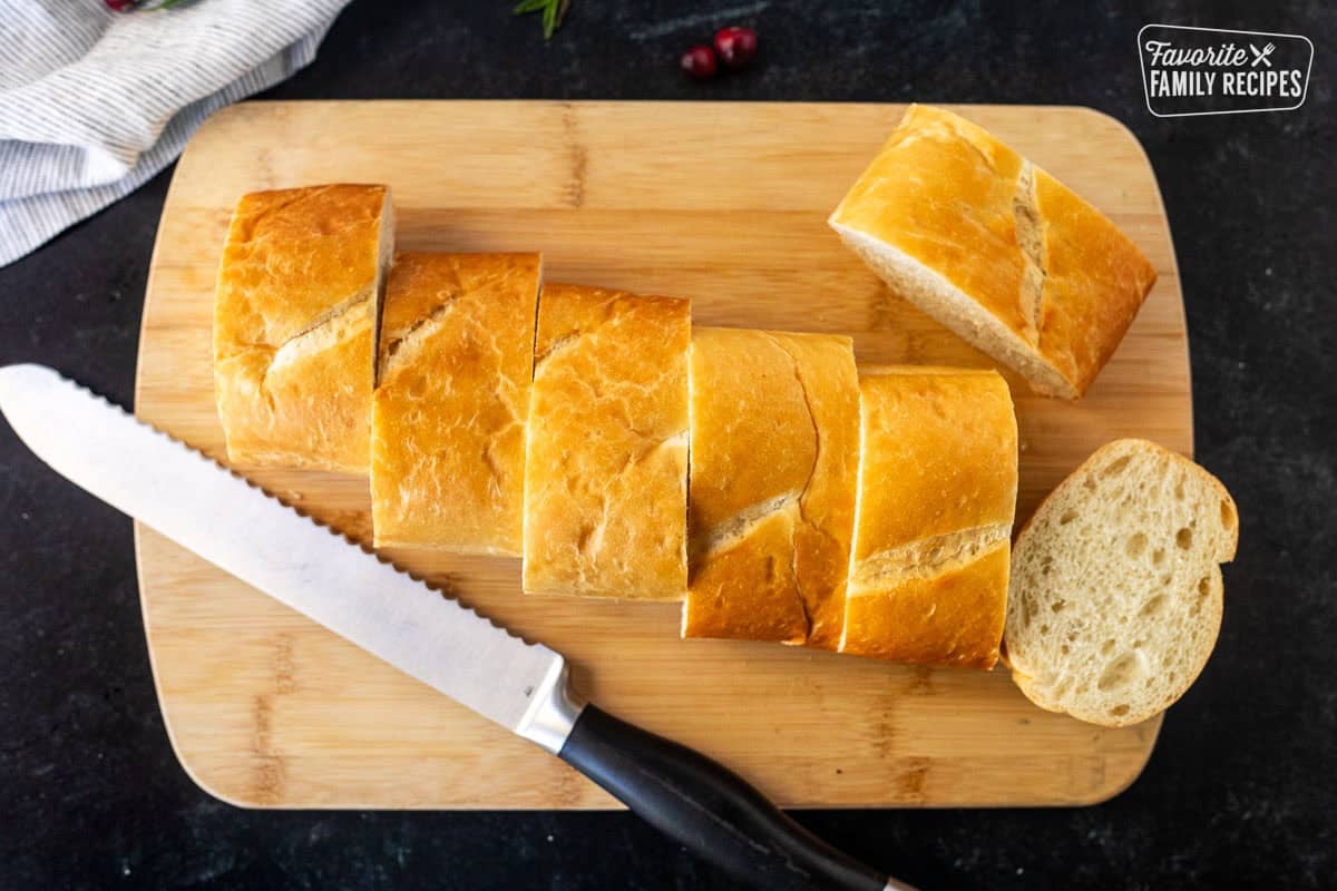 Sliced French bread loaf on a cutting board.