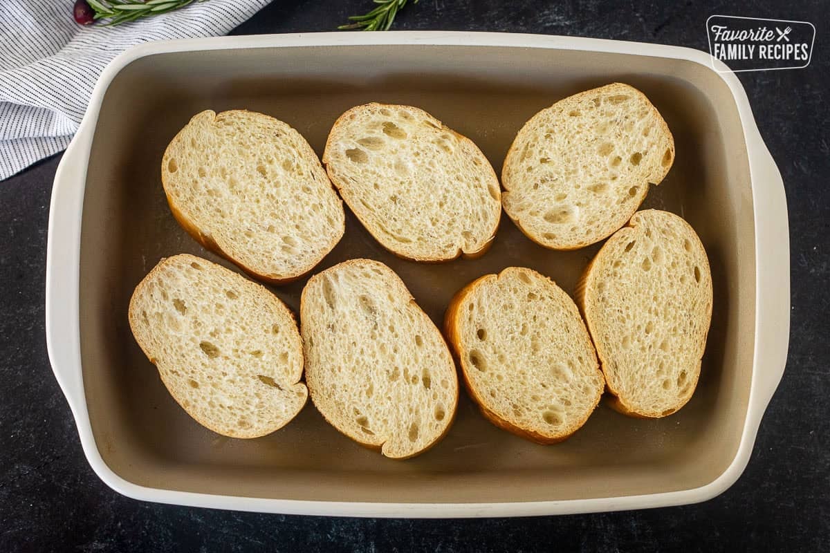 Sliced French loaf bread in a baking dish.
