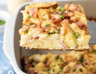 Cut piece of Eggs Benedict Casserole on a spatula.