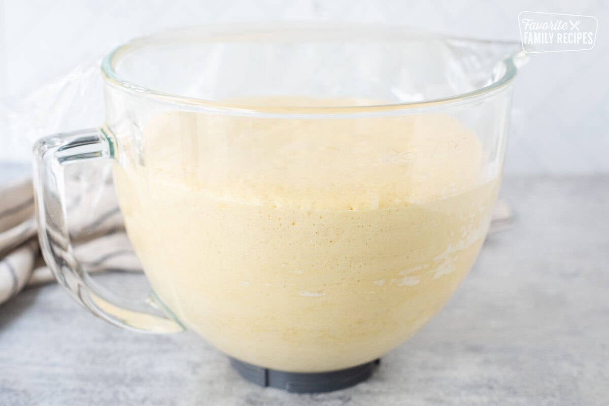 Glass bowl of Sally Lunn Bread dough rising and doubled in size.