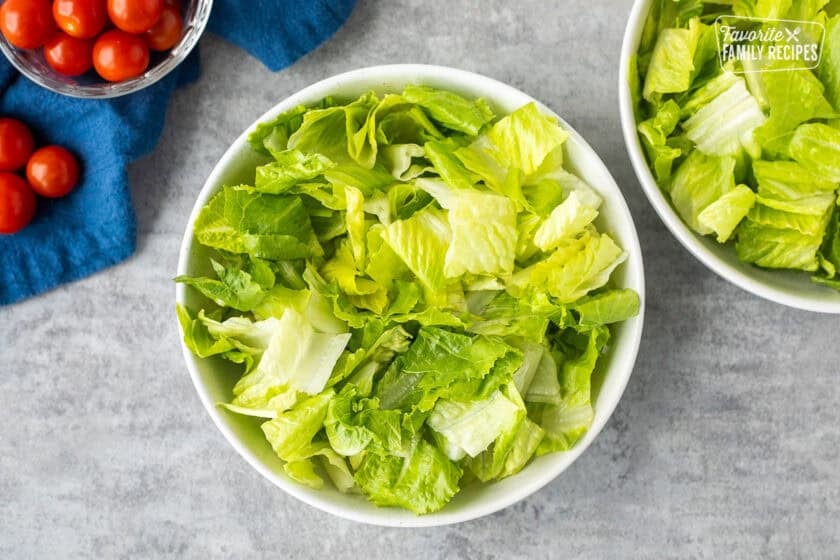 Glass bowls with chopped romaine lettuce.