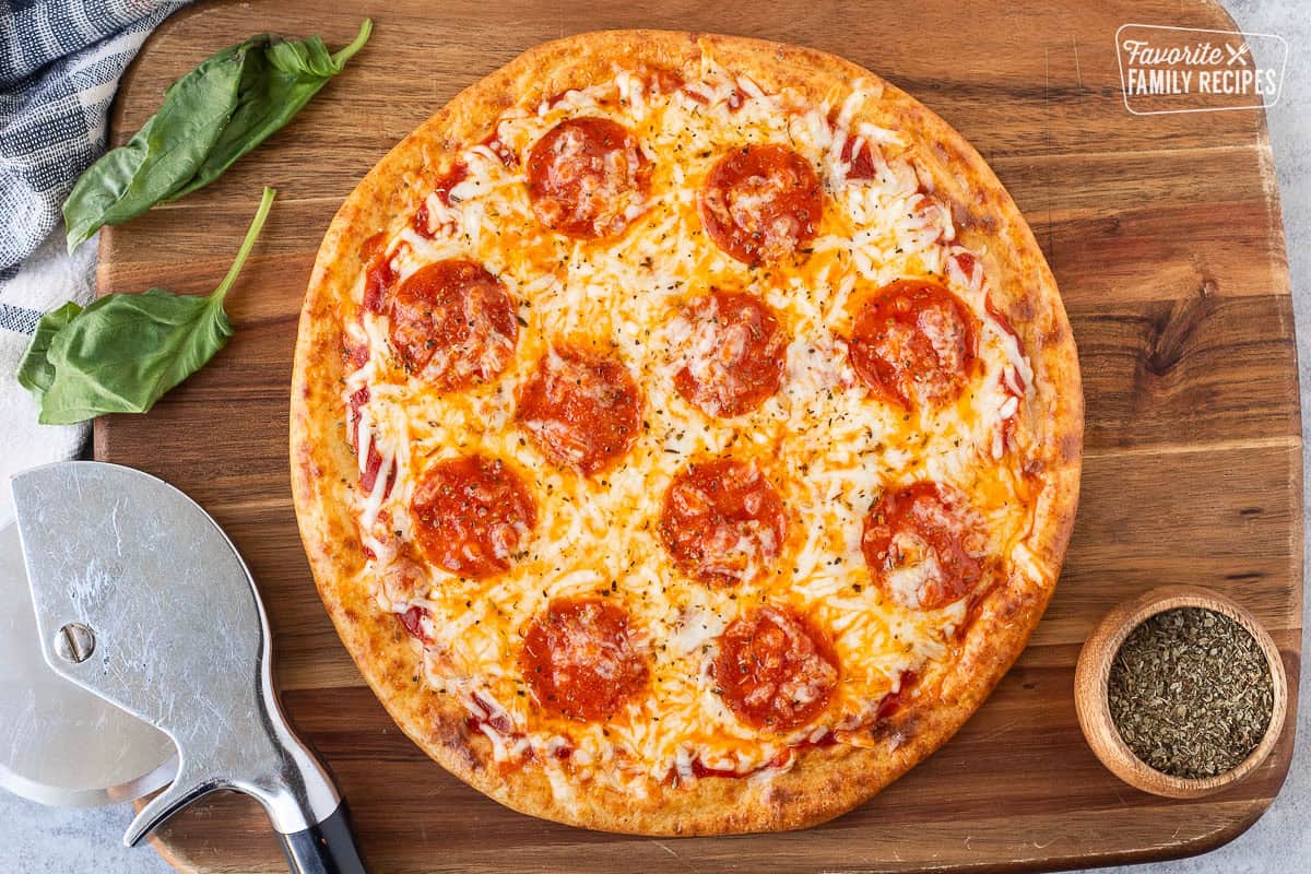 Baked pepperoni pizza on cottage cheese pizza crust with a pizza slicer on the side.