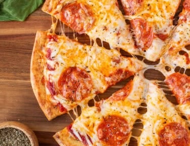 Sliced cheesy pepperoni pizza on a cottage cheese crust.