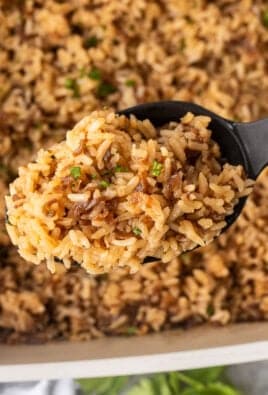 French onion rice in a large serving spoon over casserole dish.