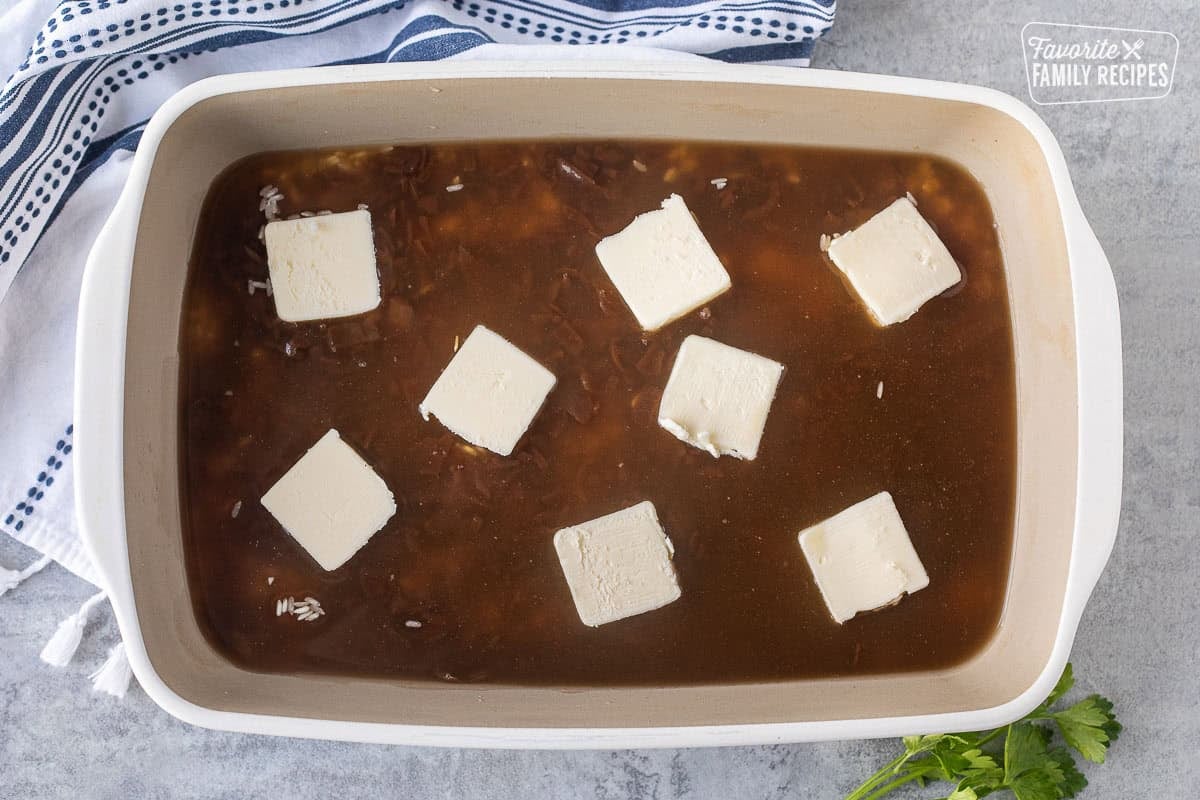 Cut cubes of butter on top of French onion soup and water to bake French onion soup rice