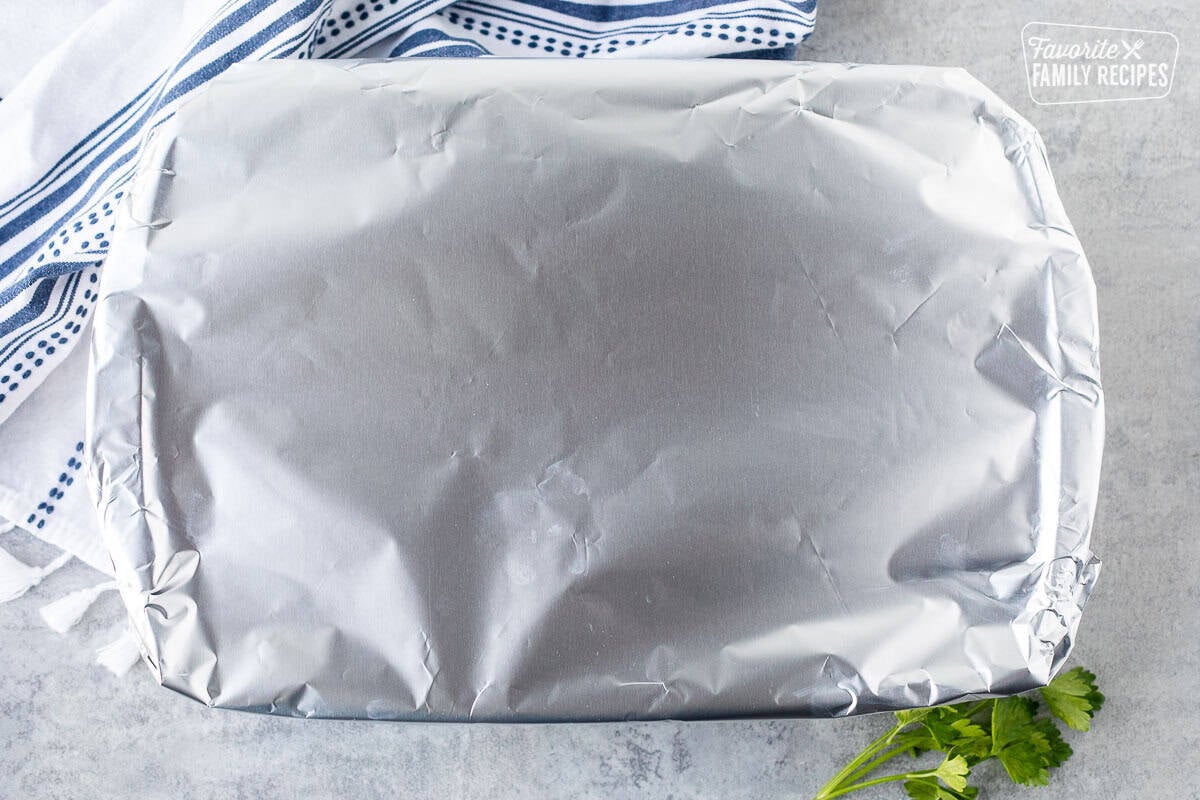 Foil covering baking dish of French onion rice prior to baking in the oven
