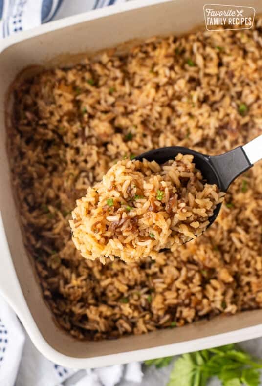 French onion rice in a large serving spoon over casserole dish.