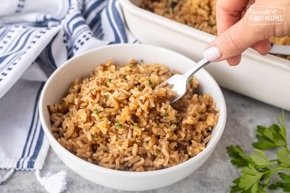 Fork in a bowl fluffing French onion rice.