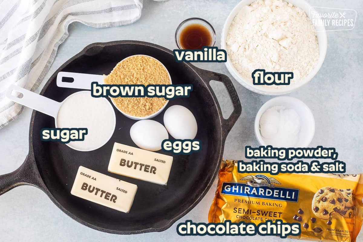 Ingredients to make Pizookie including a skillet, flour, sugar, brown sugar, eggs, butter, chocolate chips, vanilla, baking soda, baking powder and salt.