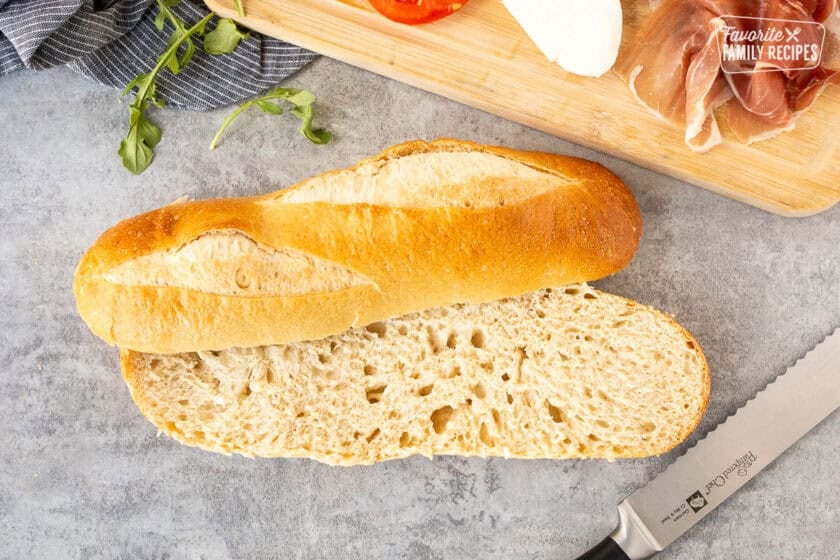 Demi French bread cut in half with a bread knife.