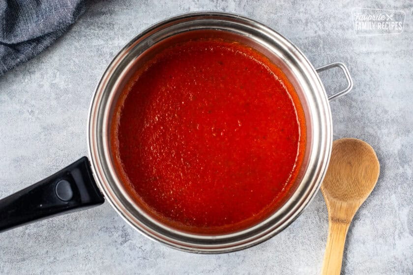 Warmed marinara sauce in a saucepan.