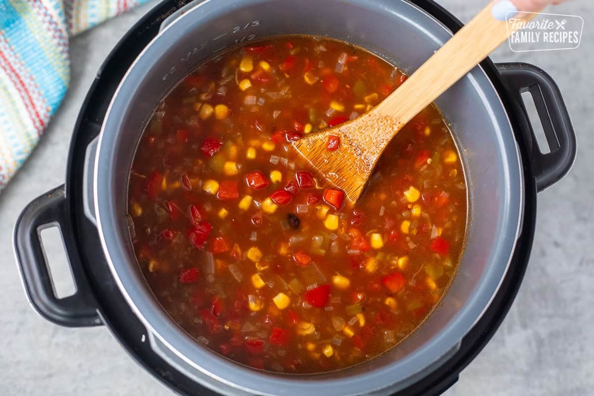 Instant Pot with red peppers, onion, beans, corn, tomatoes and sauces.