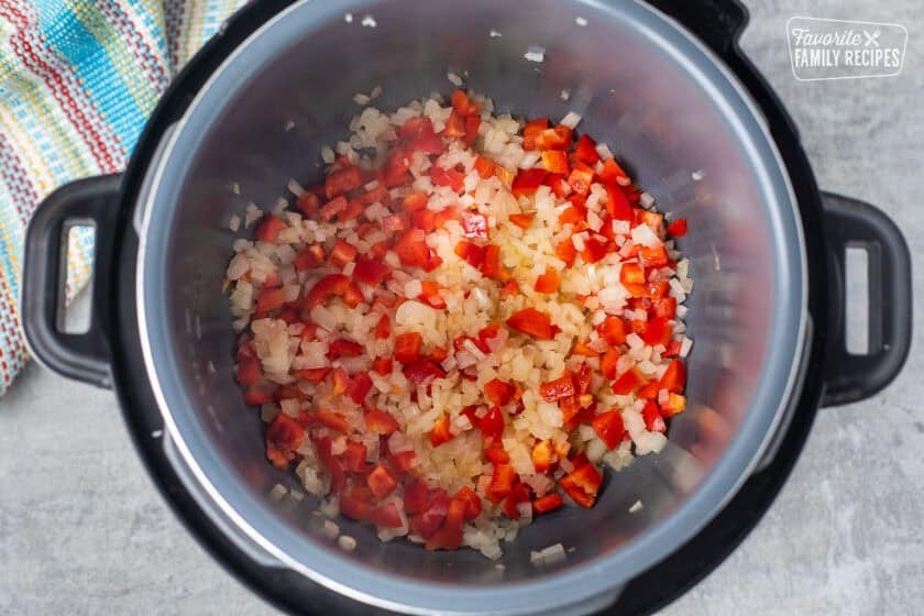 Instant Pot with chopped onions and red bell pepper.
