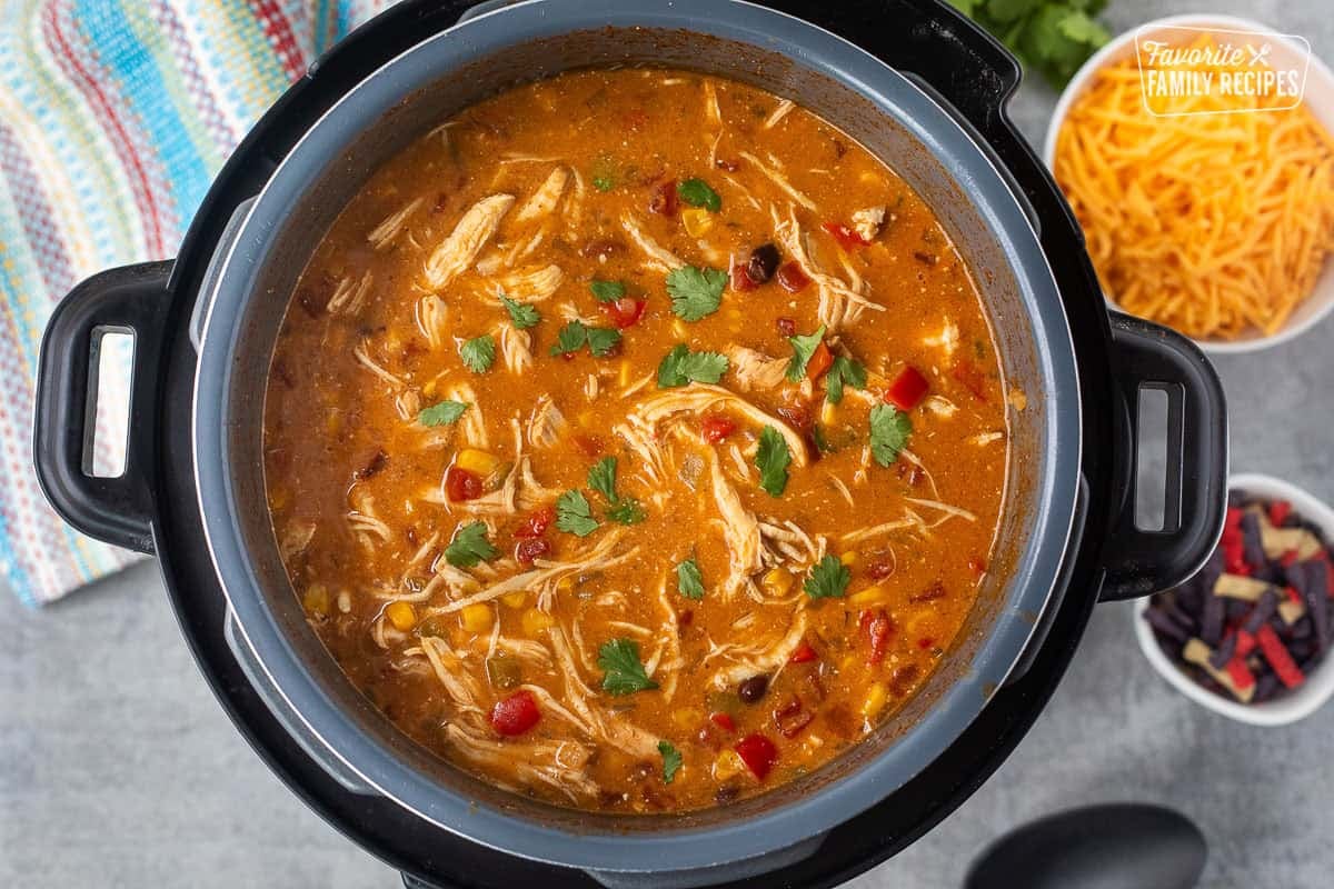 Enchilada soup in instant pot garnished with cilantro.