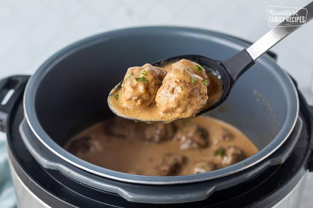 Large serving spoon with three instant pot Swedish meatballs.