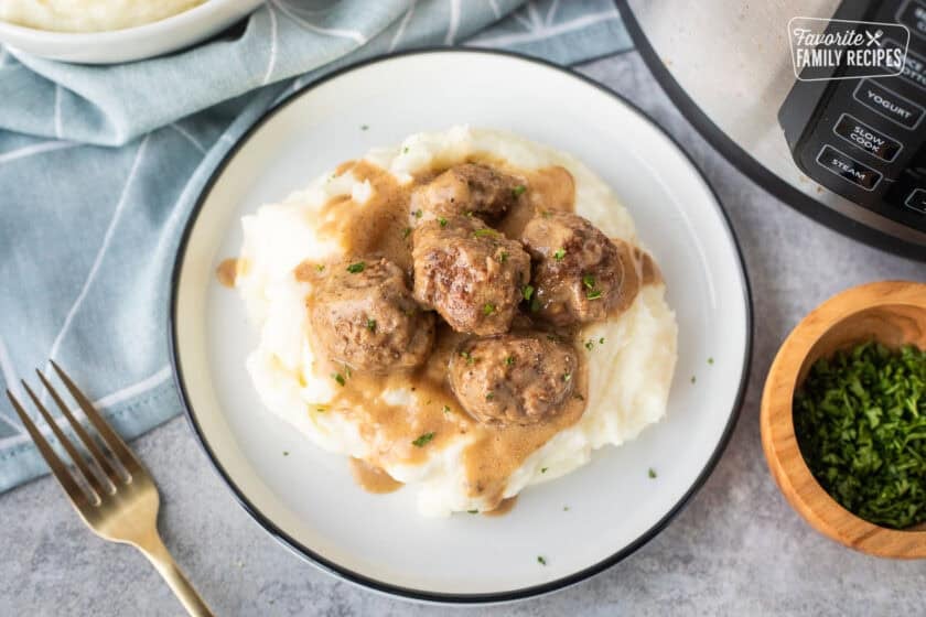 Swedish meatballs over mashed potatoes next to instant pot.