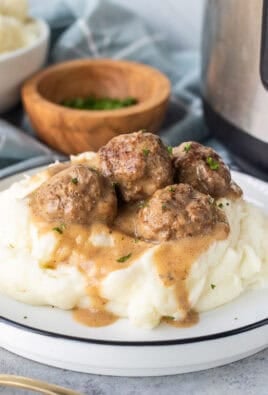 Plate of Swedish meatballs over mashed potatoes next to instant pot.