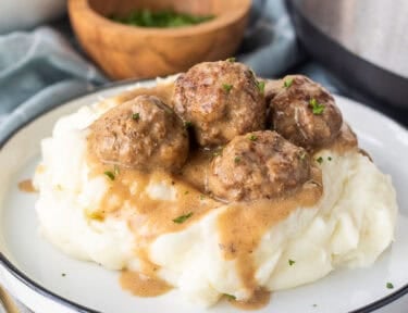 Swedish meatballs over mashed potatoes next to instant pot.