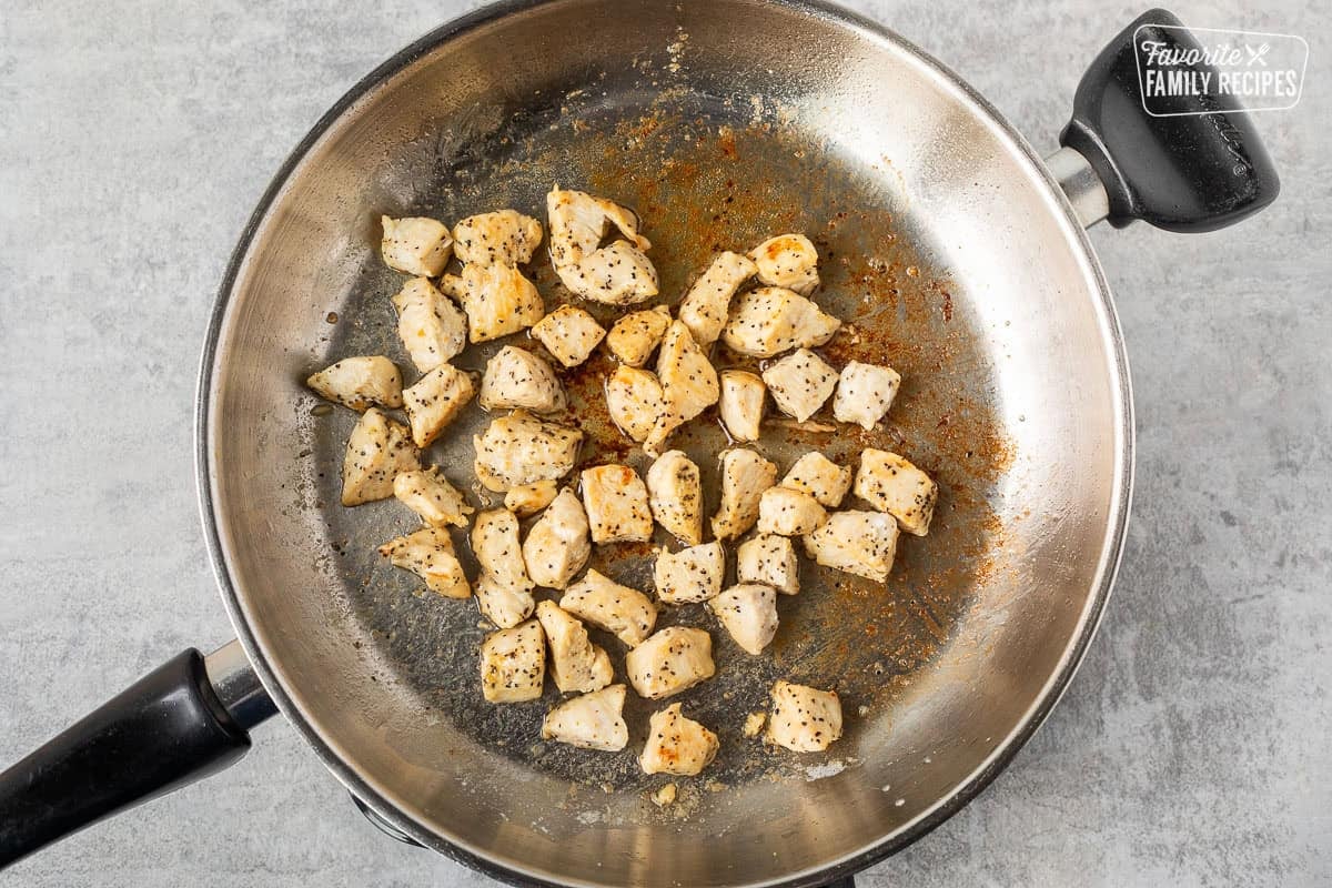 Skillet with cooked lemon pepper chicken in butter.