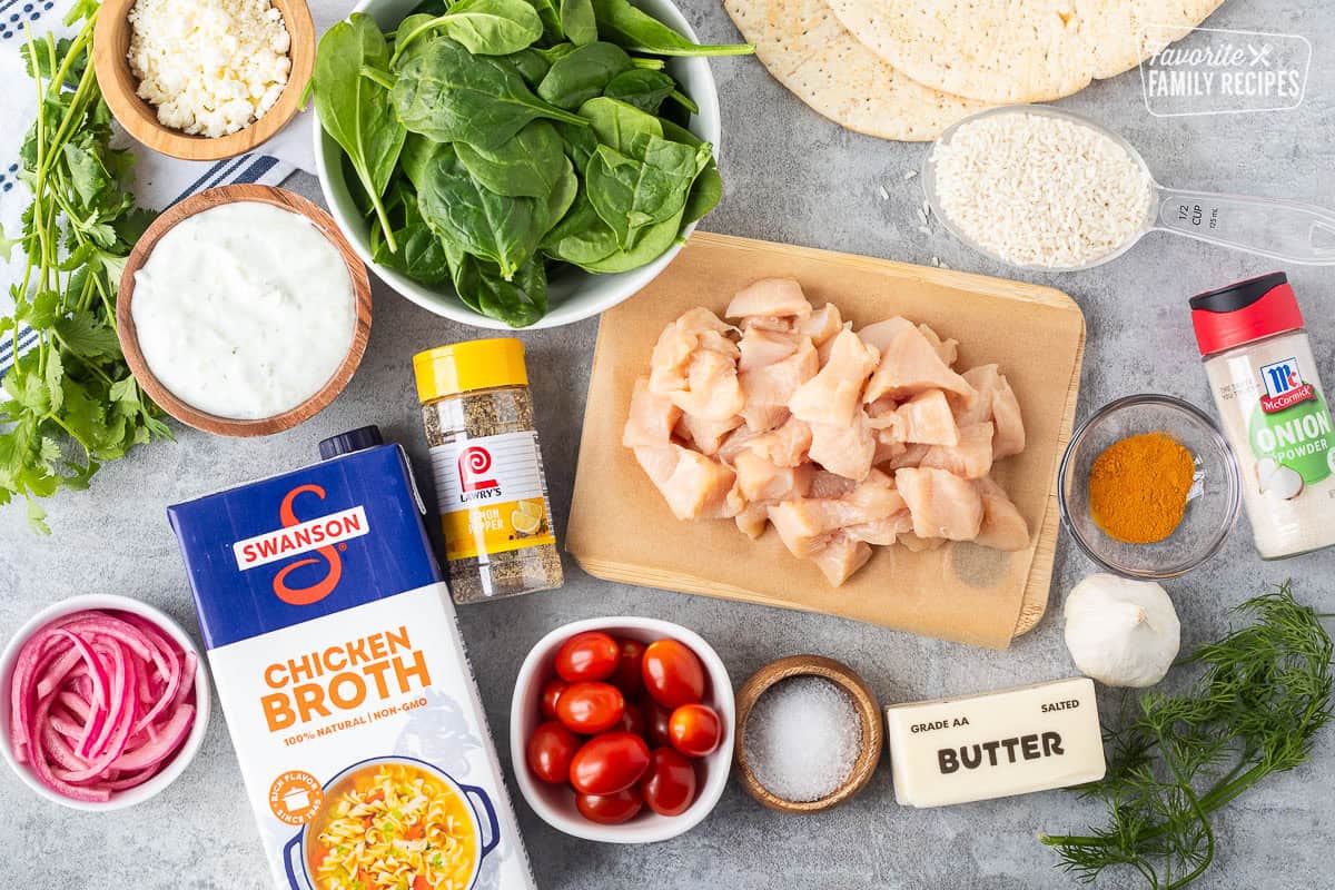 Ingredients to make Mediterranean Bowls including chicken, rice, onion powder, turmeric powder, garlic, dill, butter, salt, tomatoes, chicken broth, lemon pepper seasoning, pickled red onions, tzatziki sauce, feta, spinach, cilantro and pita bread.