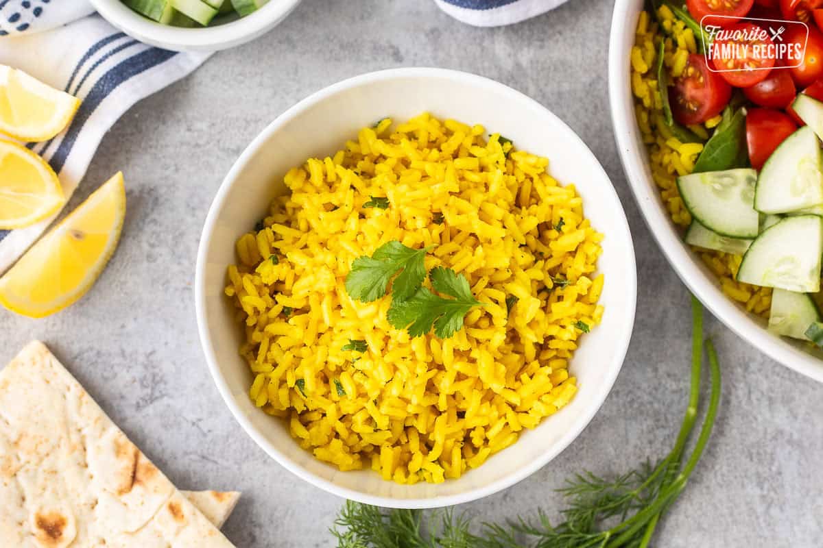 Bowl of yellow seasoned rice garnished with cilantro.