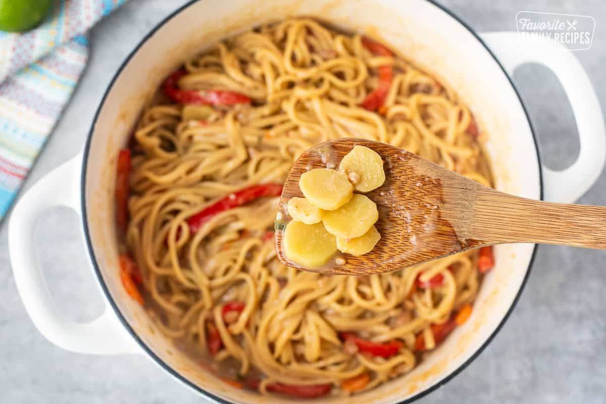 Removing ginger from Pot of Thai peanut noodles.