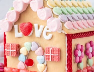 Valentine's Day Gingerbread House decorated with candies.